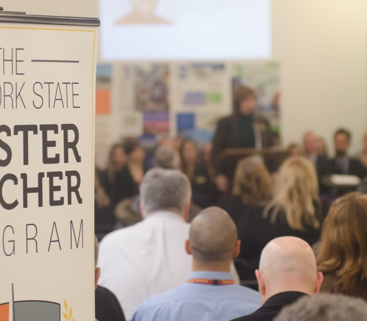 A sign that reads The New York State  Master Teacher Program next to a group of people 