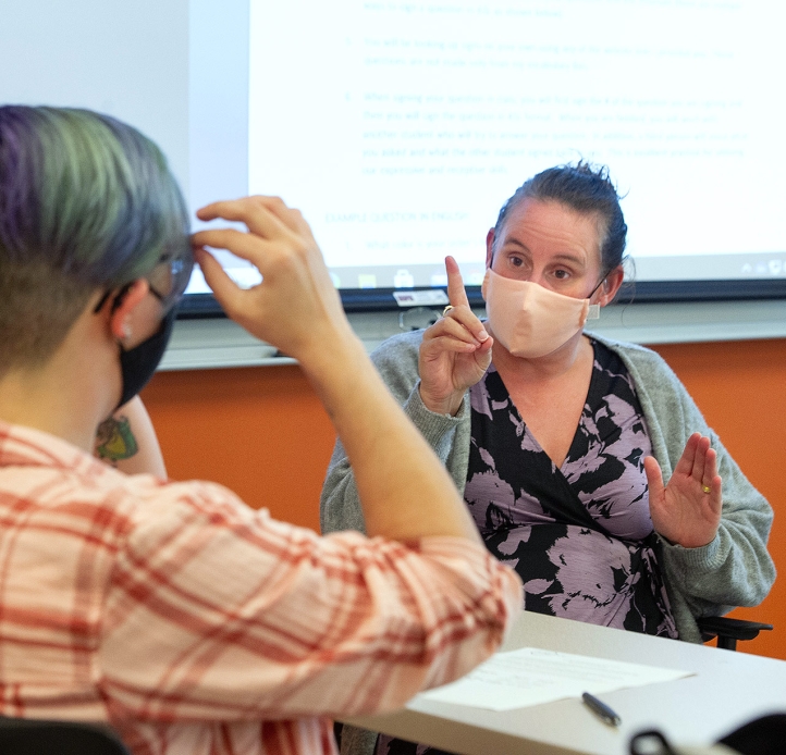 professor teaching a student American Sign Language