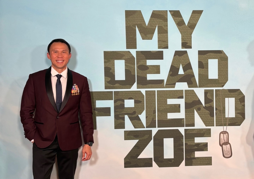 Thom Tran in front of a poster that reads My Dead Friend Zoe